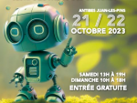 Image d'un petit robot vert qui pointe sur les dates du Villages des Sciences et de l'Innovation 2023: les 12 et 22 octobre 2023, à Antibes Juan Les Pins.